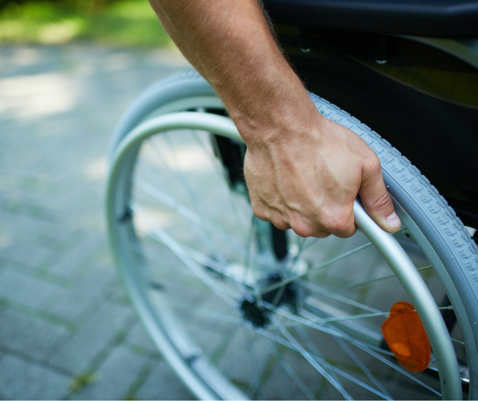 Hand on the wheel of a wheelchair, one of the most commonly used types of durable medical equipment