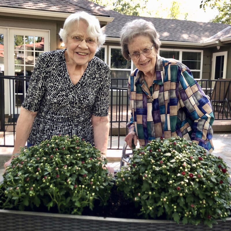 At home with memory care assisted living: 2 residents gardening