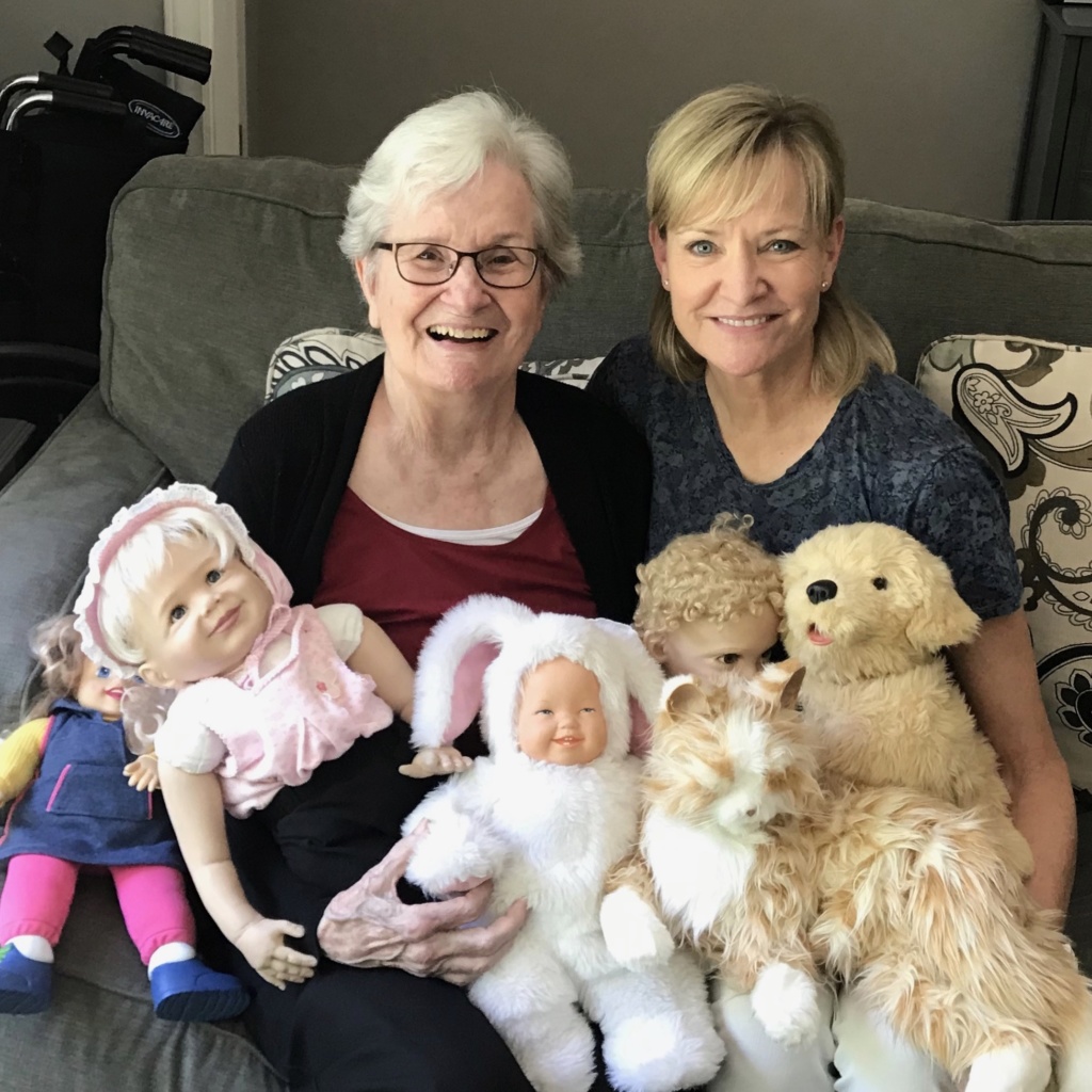 The key to photographing older adults is to keep your camera at the ready, capturing the impromptu shot of Mom & daughter surrounded by her doll "babies"